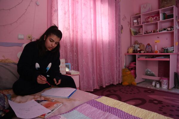 دانش آموز فلسطینی در اتاقش مشغول  اجرای کارهای خانگی مکتب - اسپوتنیک افغانستان  