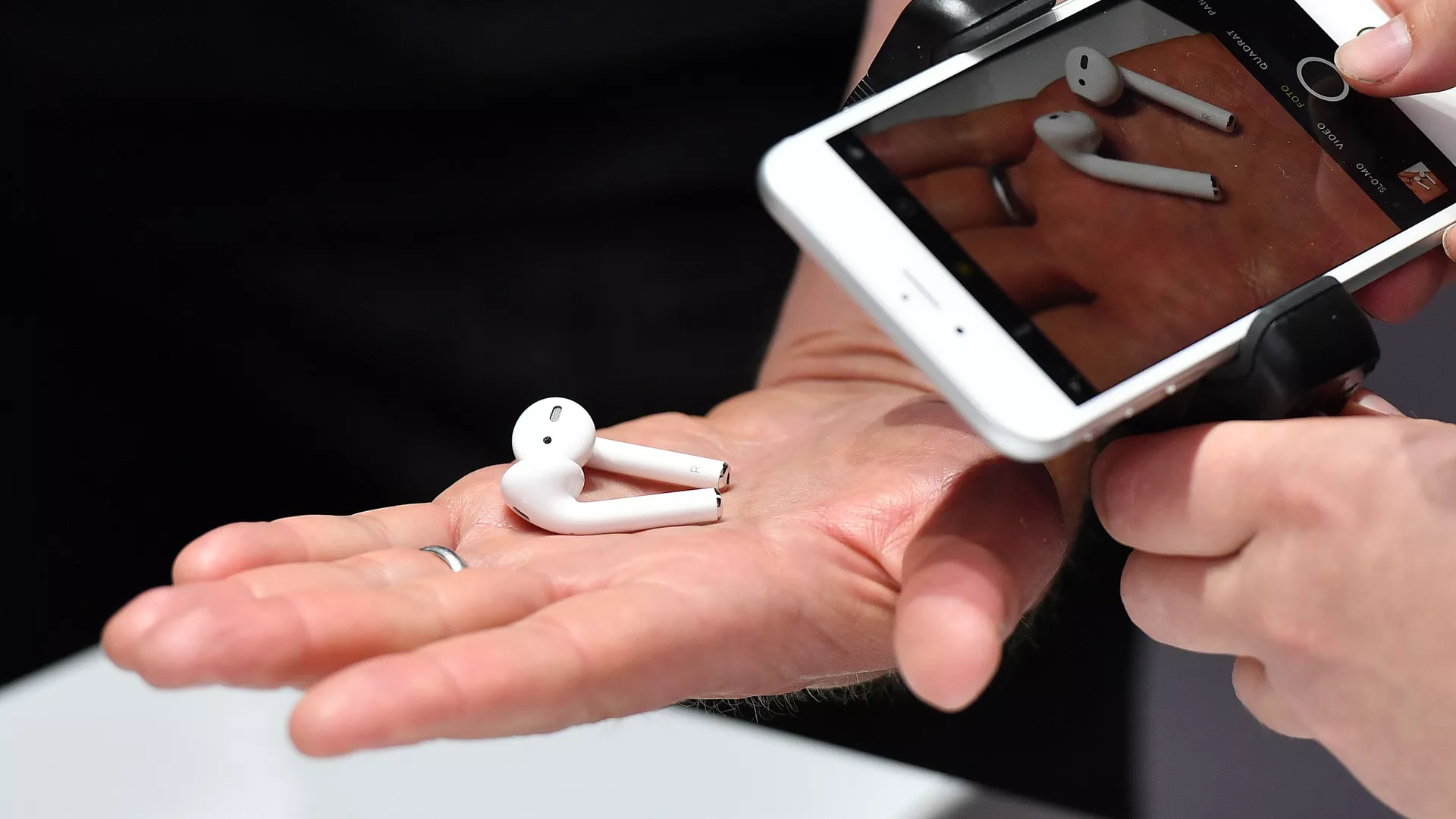 Посетитель фотографирует новые беспроводные наушники AirPods на презентации новых продуктов компании Apple в Сан-Франциско 