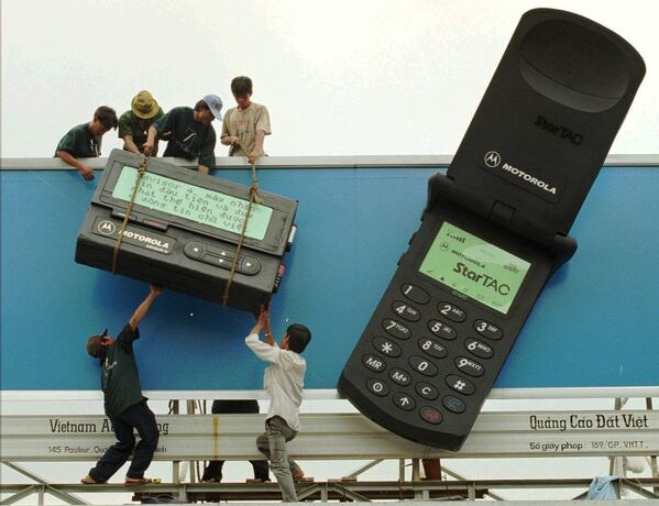 کارگران در حال جابجاسازی نمونه اعلاناتی تلفون همراه موتورولا، ۱۸ اکتوبر سال ۱۹۹۶ - اسپوتنیک افغانستان  