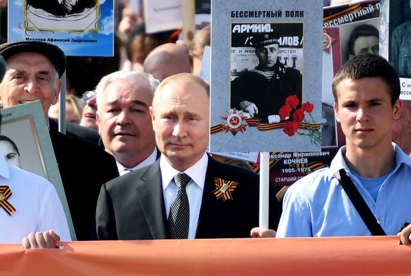 ولادیمیر پوتین، رئیس جمهور روسیه با تصویر پدر خود در گردهمایی «کندک جاویدان» - مسکو - اسپوتنیک افغانستان  
