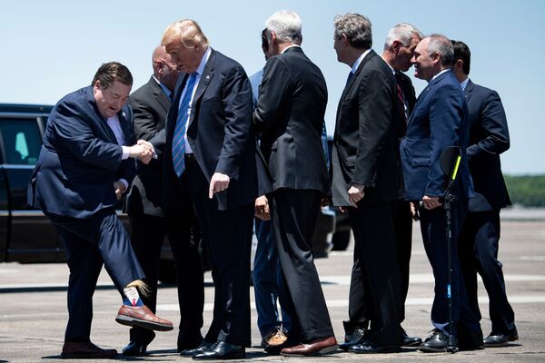 بیلی نونگرس، معاون والی ایالت لوئیزیانا در حال نشان دادن جوراب های اش به رئیس جمهور ترامپ - اسپوتنیک افغانستان  