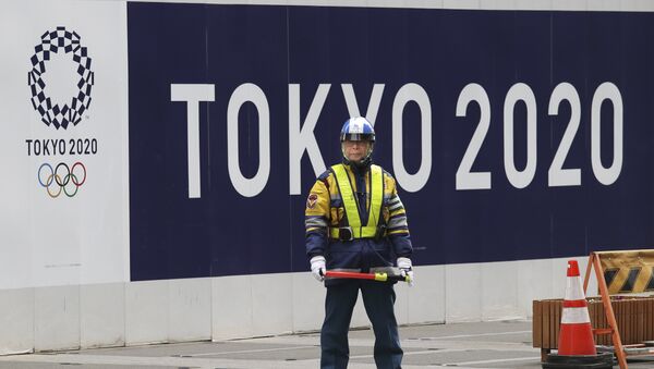 A security guard stands in front of an official logo of the 2020 Tokyo Olympic Games on the safety wall at a construction site in Tokyo's Nihonbashi shopping and office district, Monday, Feb. 6, 2017 - اسپوتنیک افغانستان  