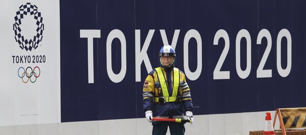 A security guard stands in front of an official logo of the 2020 Tokyo Olympic Games on the safety wall at a construction site in Tokyo's Nihonbashi shopping and office district, Monday, Feb. 6, 2017 - اسپوتنیک افغانستان  