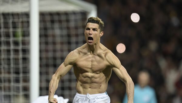 Real Madrid's Portuguese forward Cristiano Ronaldo celebrates after scoring a penalty during the UEFA Champions League quarter-final second leg football match between Real Madrid CF and Juventus FC at the Santiago Bernabeu stadium in Madrid on April 11, 2018.  - اسپوتنیک افغانستان  