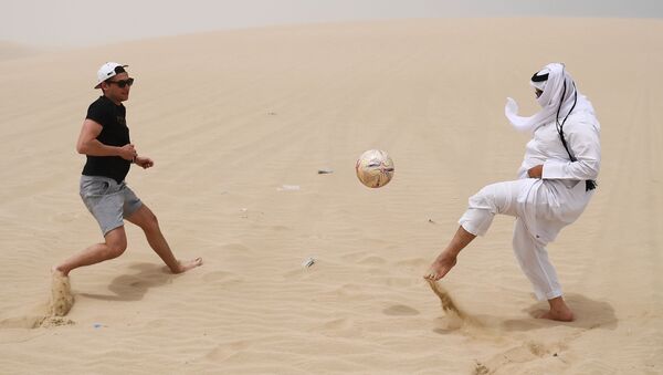 Мужчины играют в футбол в пустыне Khor Al Adaid в Дохе - اسپوتنیک افغانستان  