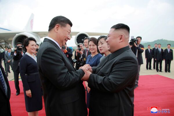 کیم جونگ اون، رهبر کوریای شمالی هنگام استقبال از شی جین‌پینگ، رئیس جمهور چین در میدان هوایی پیونگ‌یانگ - اسپوتنیک افغانستان  