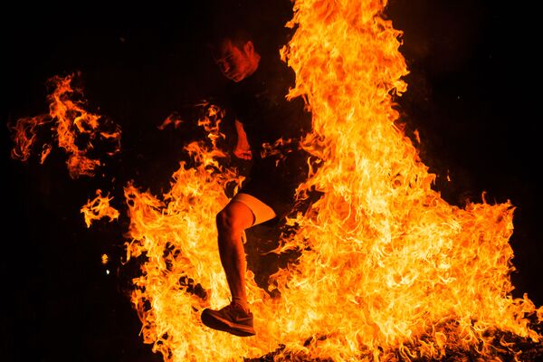 مردی در حال پریدن از روی آتش در یکی از جشن های مقدس اسپانیا - اسپوتنیک افغانستان  