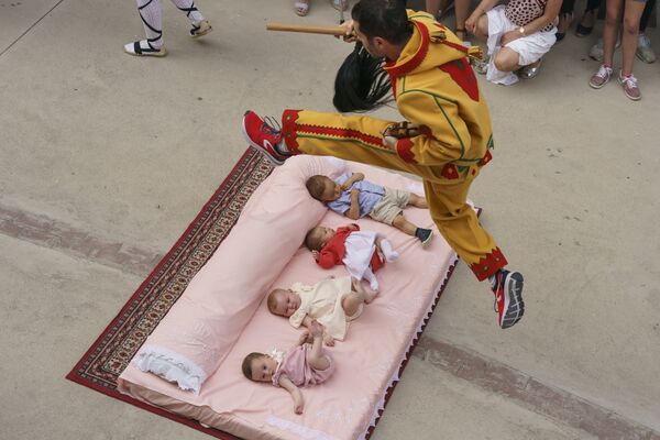 مردی در حال پرش از روی نوزادان در یکی از مراسم عنعنوی اسپانیا در کاستیلا در مورسیا - اسپوتنیک افغانستان  