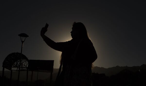 یک خانم در حال عکس گرفتگی از جریان خورشید گرفتگی در بولیویا - اسپوتنیک افغانستان  