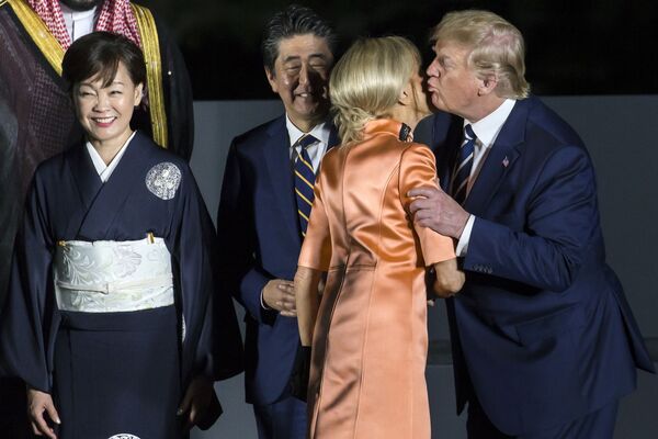 رئیس جمهور امریکا دونالد ترامپ در حال بوسیدن بریجیت مکرون همسر رئیس جمهور فرانسه - اسپوتنیک افغانستان  