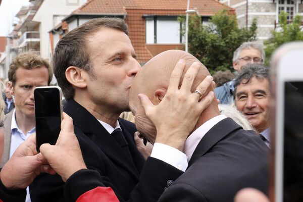 رئیس جمهور فرانسه امانوئل مکرون در حال بوسیدن طرفدار خود پس از رای گیری - اسپوتنیک افغانستان  