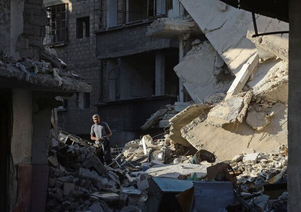 باشنده محلی در خیابان در بین ساختمان های ویران شده در منطقه دهانییه در دمشق - اسپوتنیک افغانستان  