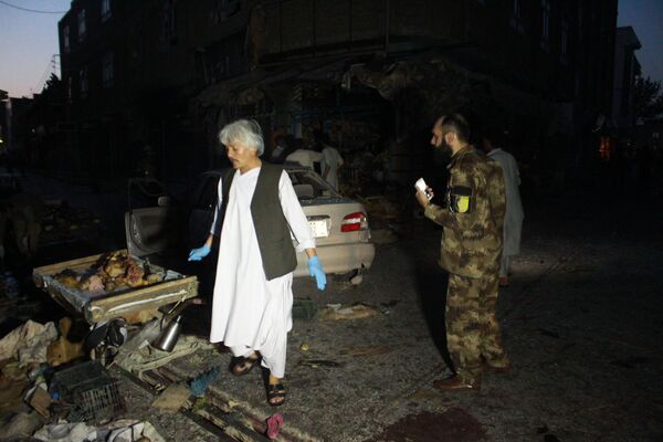کارمند امنیت ملی و یکی از افراد ملکی پس از وقوع انفجار در هرات در حال جستجوی قربانیان - اسپوتنیک افغانستان  