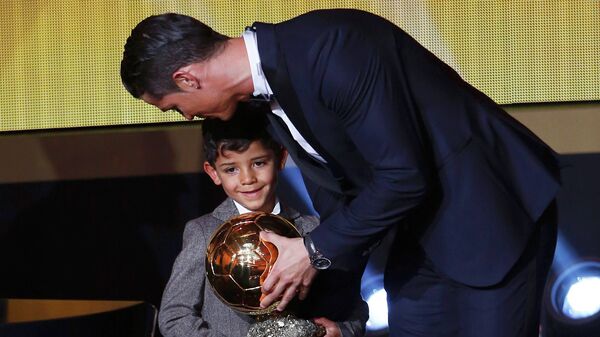 Real Madrid's Cristiano Ronaldo of Portugal, stands with his son Cristiano Ronaldo Jr, after winning the FIFA Ballon d'Or 2014 during the soccer awards ceremony at the Kongresshaus in Zurich January 12, 2015 - اسپوتنیک افغانستان  
