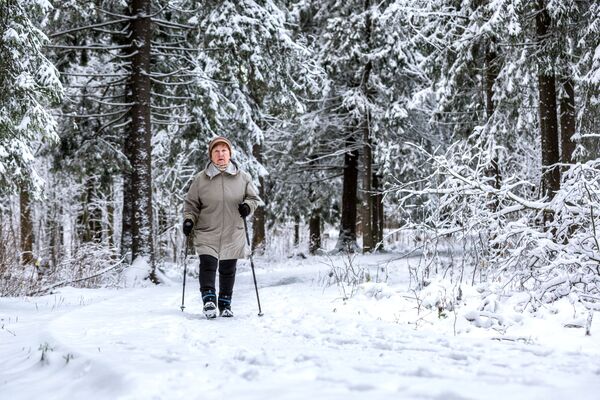 زنی در حال قدم زدن در پارک پوشیده از برف در پتروزاودسک روسیه  - اسپوتنیک افغانستان  