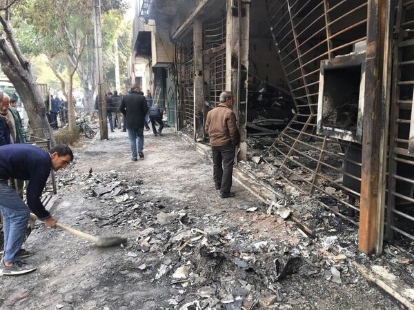 رهگذران در ساختمان بانک سوخته پس از اعتراضات در اصفهان - اسپوتنیک افغانستان  