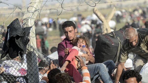 Сирийские беженцы перелезают через сломанный забор на границе с Турцией - اسپوتنیک افغانستان  