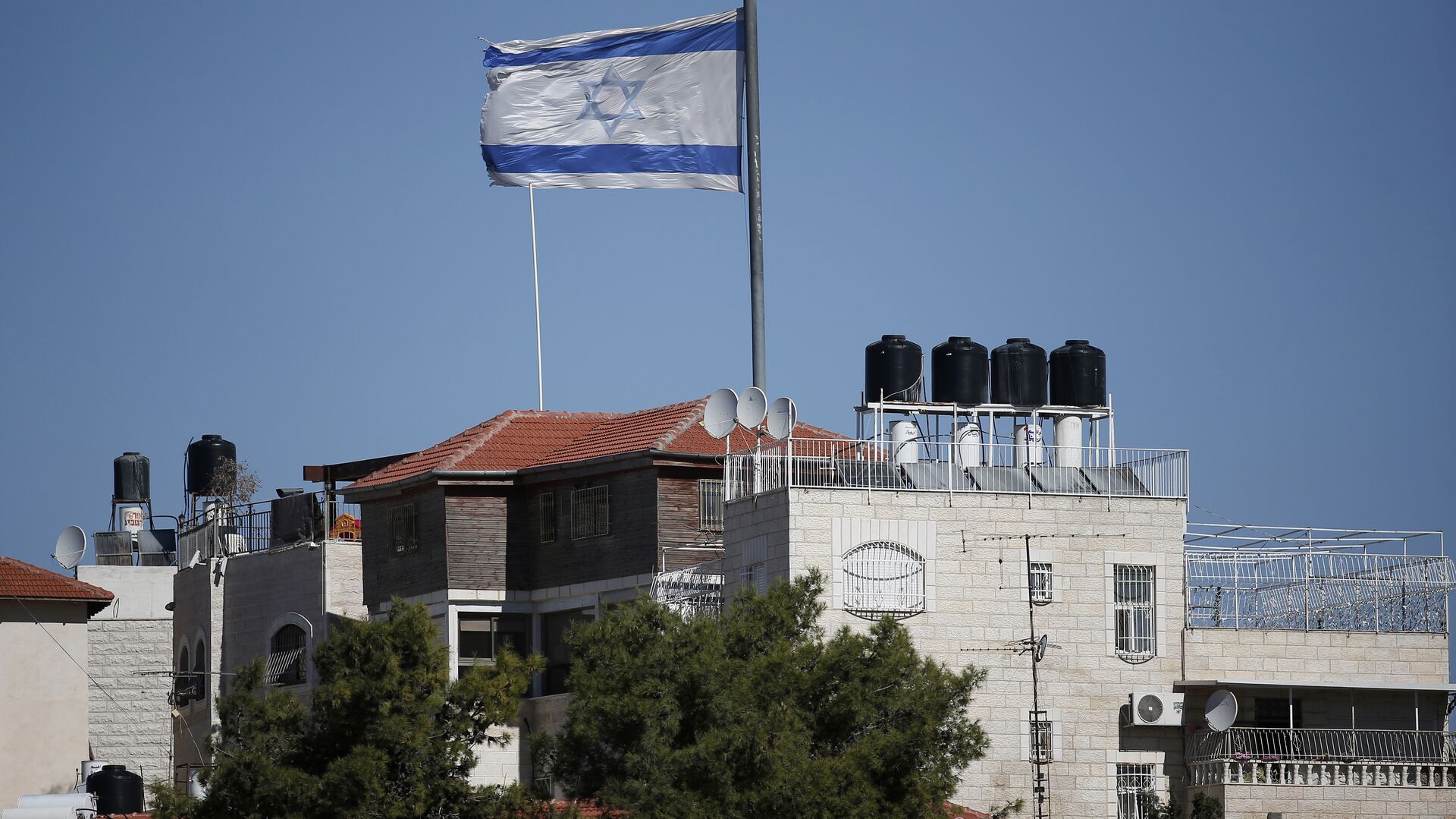 A giant Israeli flag flies over a settlement building situated in the middle of a Palestinian neighbourhood of Al-Tur in East Jerusalem, on November 11, 2014 - اسپوتنیک افغانستان  , 1920, 13.06.2022