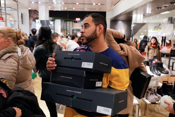 Работник в Мэйси несет коробки для покупателей во время Черную пятницы, Нью-Йорк - اسپوتنیک افغانستان  