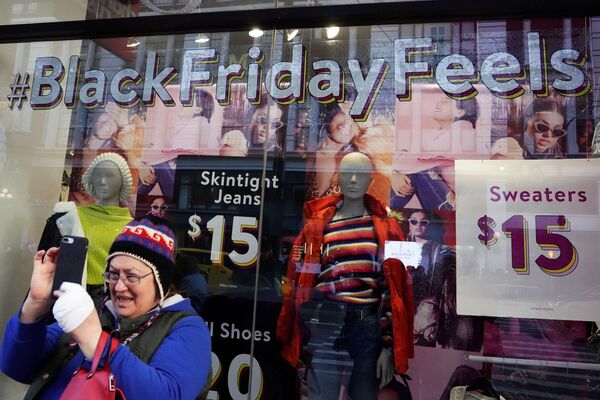 Женщина снимает селфи у магазина с рекламой Черной пятницы в Нью-Йорке, США - اسپوتنیک افغانستان  