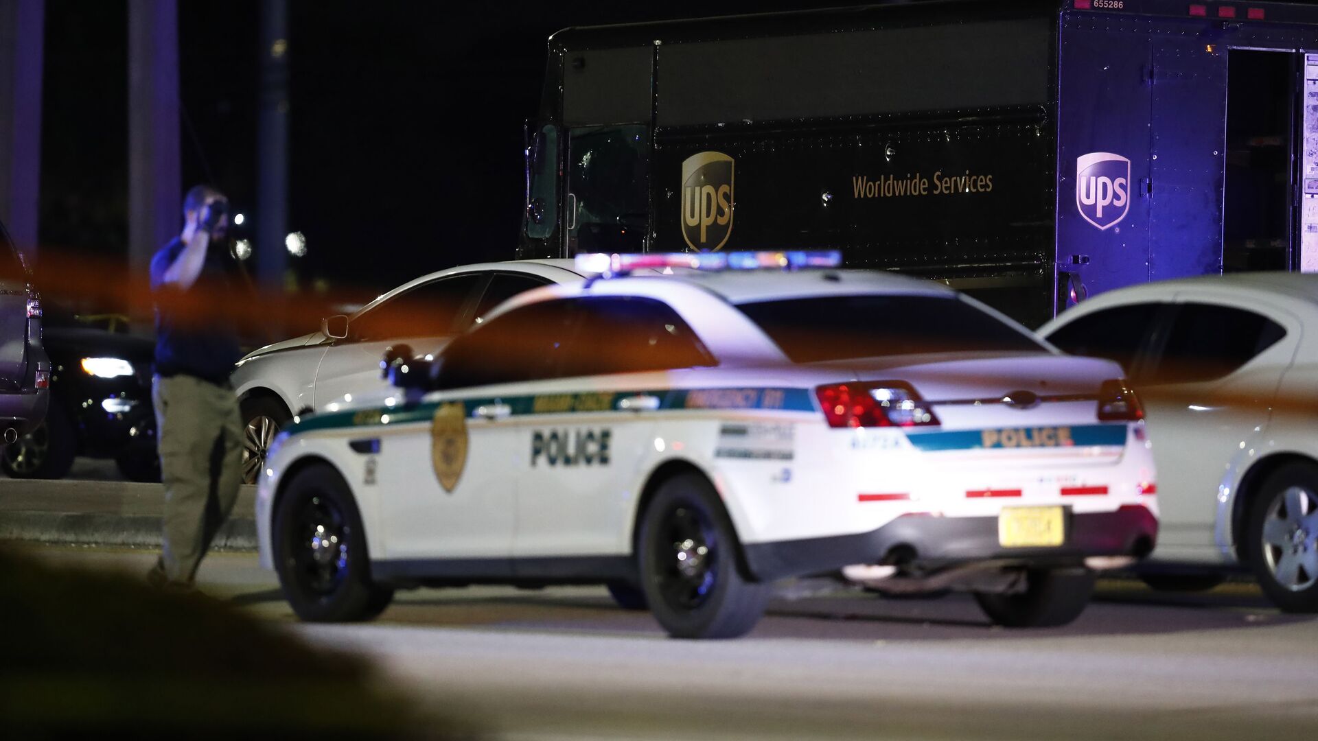 Authorities walk near a UPS truck and other vehicles at the scene of a shooting, Thursday, Dec. 5, 2019, in Miramar, Fla. - اسپوتنیک افغانستان  , 1920, 05.01.2022
