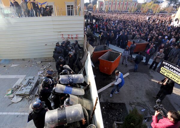 حامیان حزب دموکرات در حال تلاش برای از بین بردن مانع در نزدیکی وزارت داخله كشور در طول تظاهرات ضد دولتی در تیرانا، آلبانیا - اسپوتنیک افغانستان  