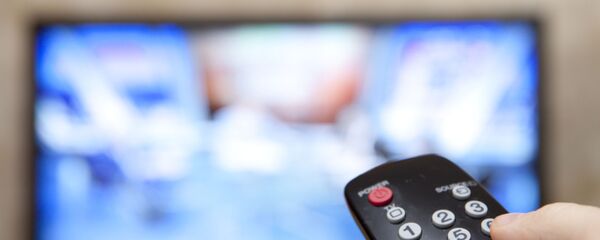 Мужчина держит пульт перед телевизором Мужчина держит пульт перед телевизором - اسپوتنیک افغانستان