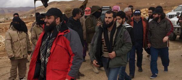 Al Qaeda-linked Nusra Front fighters (back L) stand as Lebanese soldiers and policemen (C) are released in Arsal, eastern Bekaa Valley, Lebanon, December 1, 2015 Al Qaeda-linked Nusra Front fighters (back L) stand as Lebanese soldiers and policemen (C) are released in Arsal, eastern Bekaa Valley, Lebanon, December 1, 2015 - اسپوتنیک افغانستان
