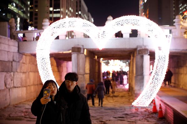 یک جفت عاشق در حال عکس‌گرفتن در جریان تجلیل از سال نو در سئول، کوریای جنوبی - اسپوتنیک افغانستان  