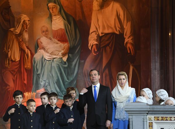 دیمیتری مدودف، نخست وزیر روسیه  و همسرش سوتلانا مدودوا در جشن کریسمس در کلیسای جامع عیسی ناجی در مسکو. - اسپوتنیک افغانستان  