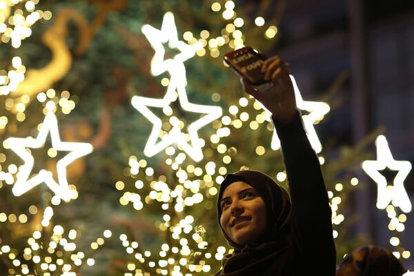 دختر لبنانی در مقابل درخت سرو میلاد مسیح در مرکز شهر بیروت مصروف عکاسی سلف می باشد - اسپوتنیک افغانستان  