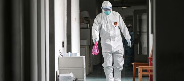 A medical worker in protective suit disinfects the hallway at Jinyintan hospital in Wuhan A medical worker in protective suit disinfects the hallway at Jinyintan hospital in Wuhan - اسپوتنیک افغانستان