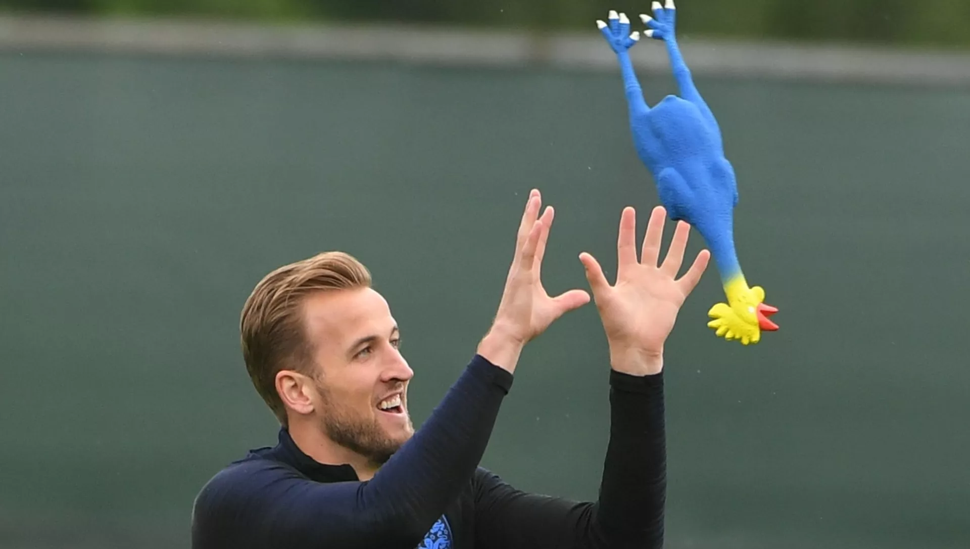 England's Harry Kane plays with a toy rooster during the national soccer team's training session in St. Petersburg, Russia, July 10, 2018.