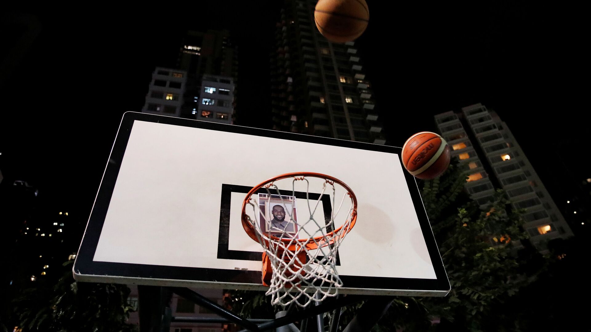 Protester throw basketballs at a hoop with NBA star Lebron James' photo during a gathering in support of NBA's Houston Rockets' team general manager Daryl Morey, who sent a tweet backing the pro-democracy movement, in Hong Kong, China, October 15, 2019 - اسپوتنیک افغانستان  , 1920, 01.08.2022