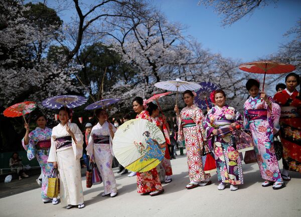 Иностранцы в кимоно на фоне цветущей вишни в Токио  - اسپوتنیک افغانستان  