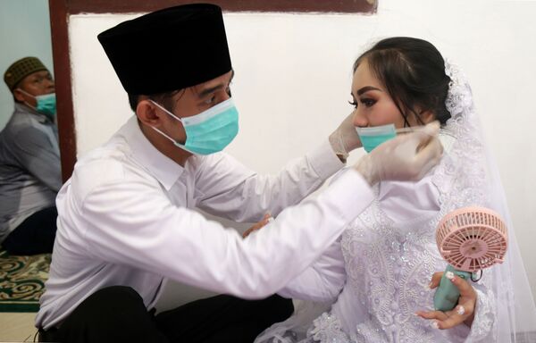 مراسم ازدواج با ماسک و دستکش سفید/عروس و داماد در جاکارتا. - اسپوتنیک افغانستان  