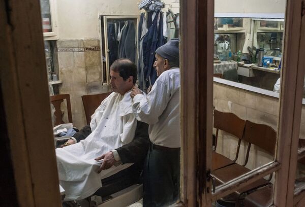 آرایشگر در حال اصلاح مردی در بازار حمیدیا در دمشق - اسپوتنیک افغانستان  