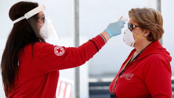 Волонтер Красного Креста проверяет температуру у посетительницы перед входом на рынок в Чистернино - اسپوتنیک افغانستان  
