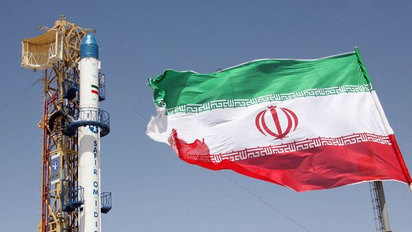 Iranian flag fluttering in front of Iran's Safir Omid rocket, which is capable of carrying a satellite into orbit, before it's launch in a space station at an undisclosed location in the Islamic republic - اسپوتنیک افغانستان  