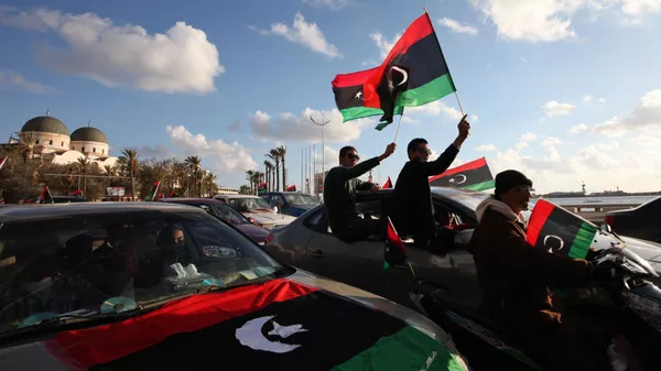 Libyans wave the national flag during commemorations to mark the second anniversary of the revolution that ousted Moammar Gadhafi in Benghazi, Libya, Friday, Feb, 15, 2013 - اسپوتنیک افغانستان