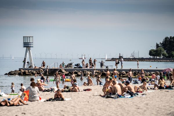 مردم از هوای گرم ساحل Bellevue در شمال کپنهاگ ، دانمارک لذت می برند.
 - اسپوتنیک افغانستان  