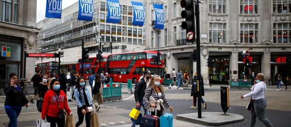 People wear protective masks as they walk at Oxford Circus, amid the coronavirus disease (COVID-19) outbreak in London, Britain, June 29, 2020. People wear protective masks as they walk at Oxford Circus, amid the coronavirus disease (COVID-19) outbreak in London, Britain, June 29, 2020. - اسپوتنیک افغانستان