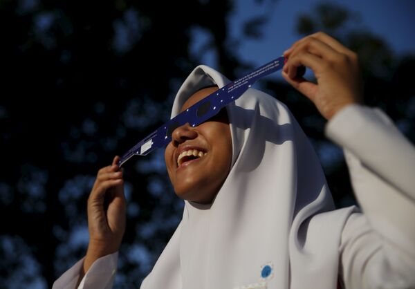 دختر مکتب در کوالالامپور از آفتاب گرفتگی نظارت میکند - اسپوتنیک افغانستان  