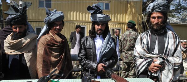 Former Taliban fighters look on as they stand alongside their weapons in Jalalabad, the capital of Nangarhar province on March 19, 2014 Former Taliban fighters look on as they stand alongside their weapons in Jalalabad, the capital of Nangarhar province on March 19, 2014 - اسپوتنیک افغانستان