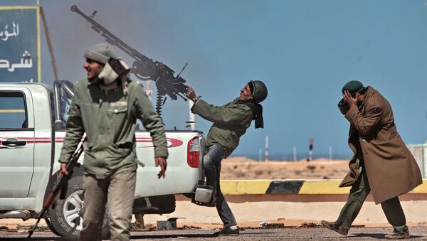 Боец оппозиции стреляет из пулемета в истребитель в городе Рас-Лануф в Ливии - اسپوتنیک افغانستان  
