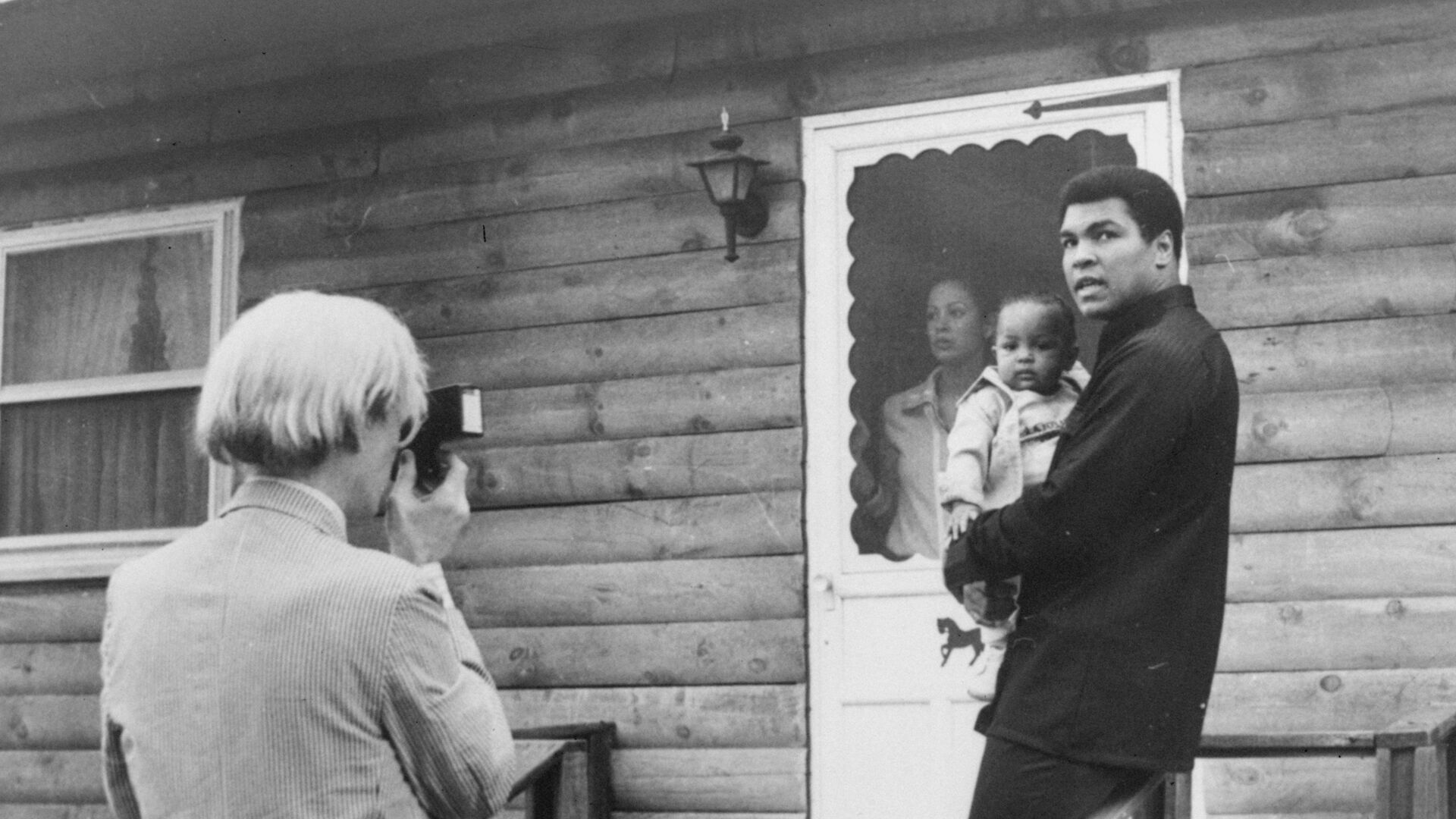 Pop artist Andy Warhol, left, is shown photographing Muhammad Ali, his infant daughter, Hanna, and wife, Veronica, Thursday, August 18, 1977, at Ali's training camp in Deer Lake, Pa. - اسپوتنیک افغانستان  , 1920, 03.06.2022