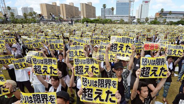 Protesters raise placards reading Anger was over the limit during a rally against the U.S. military presence on the island and a series of crimes and other incidents involving U.S. soldiers and base workers, at a park in the prefectural capital Naha on Japan's southern island of Okinawa, Japan, in this photo taken by Kyodo June 19, 2016 - اسپوتنیک افغانستان  