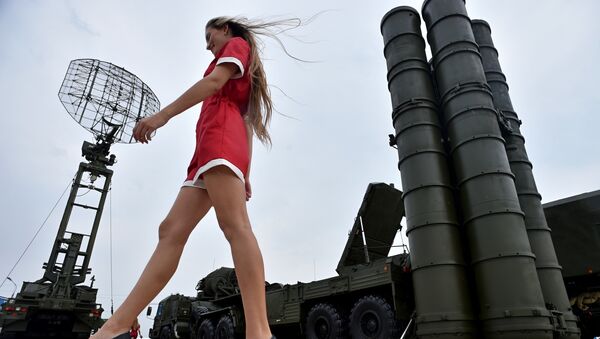 A woman walks near Russia's air defence system S-400 Triumf launch vehicles at the military exhibition - اسپوتنیک افغانستان  