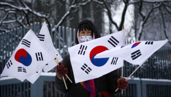 Женщина держит южнокорейские флаги во время акции протеста перед зданием посольства Северной Кореи в Берлине - اسپوتنیک افغانستان  