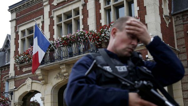 A policeman reacts as he secures a position in front of the city hall after two assailants had taken five people hostage in the church at Saint-Etienne-du -Rouvray near Rouen in Normandy, France, July 26, 2016 - اسپوتنیک افغانستان  